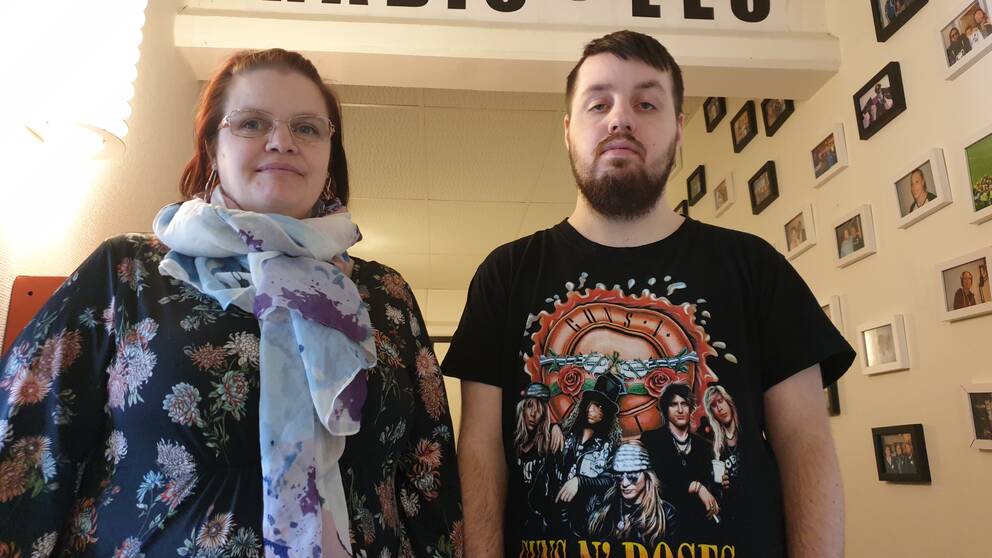 Mia och Daniel står framför en skylt där det står ”Välkommen till Radio Leo”.