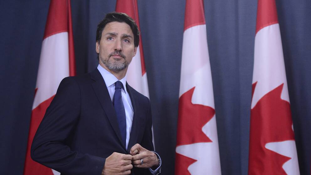 Kanadas premiärminister Justin Trudeau framför en rad kanadensiska flaggor på en presskonferens där han framför sina kondoleanser till de som förlorade anhöriga i flygkraschen i Iran den 8 januari.