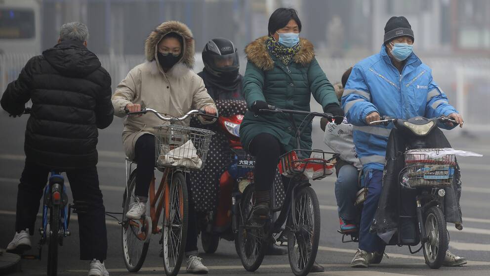 Maskklädda cykeltrafikanter i Kinas huvudstad Peking på torsdagen.