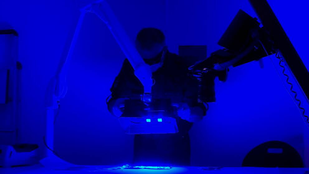 Forensikern Ulrik Lidström undersöker fingeravtryck med en så kallad crime light.