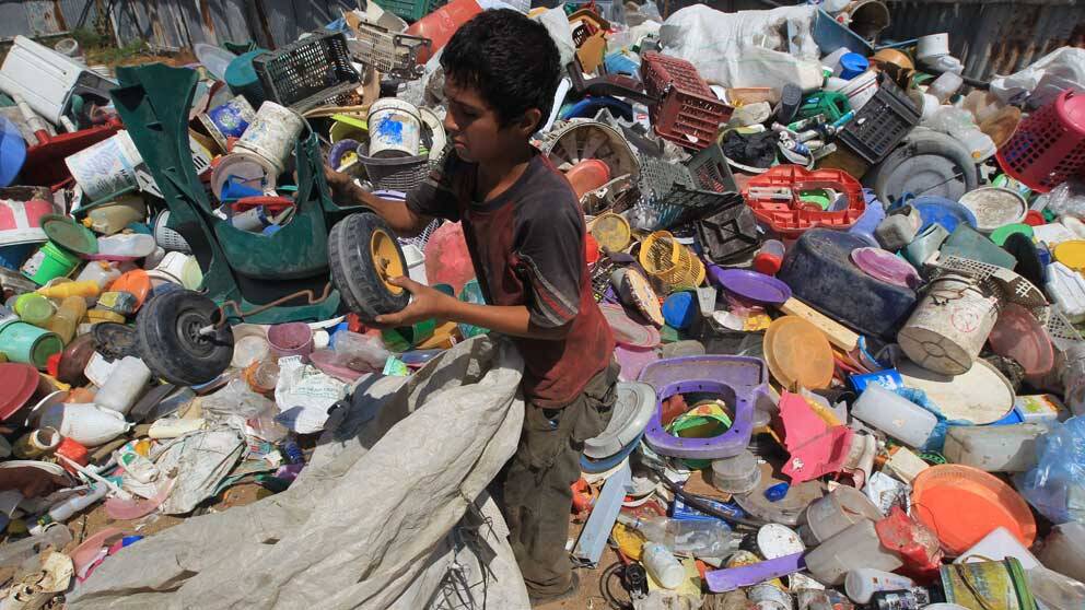 En pojke i Beit Lahia, norra Gaza, samlar plast och metall som han hoppas kunna sälja.