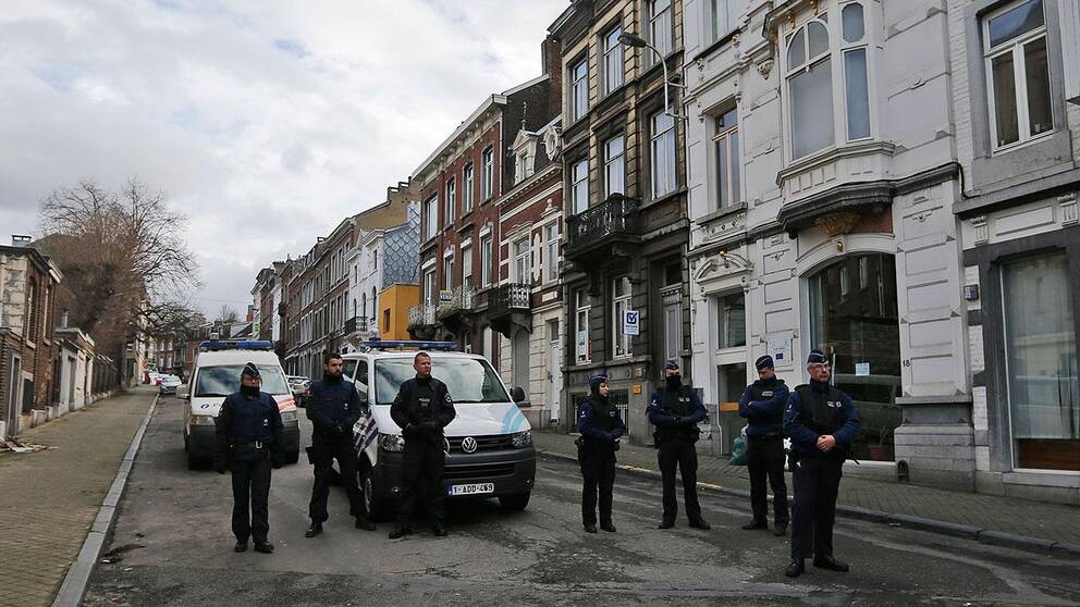 Poliser bevakar en gata i Verviers i Belgien under fredagen. Flera persober har gripits och fem är misstänkta för terrorbrott.