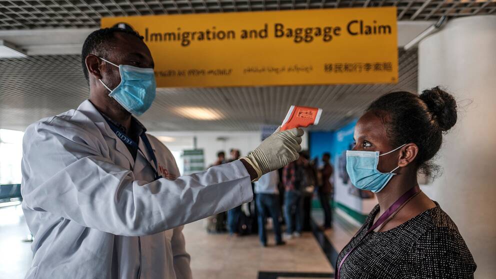 En arbetare från den etiopiska hälsomyndigheten tar tempen på en arbetare på den internationella flygplatsen i huvudstaden Addis Ababa.