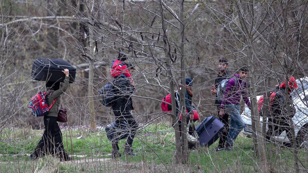 Migranter och flyktingar bär på bagage och försöker ta sig till gränsen mellan Turkiet och Grekland. Arkivbild.