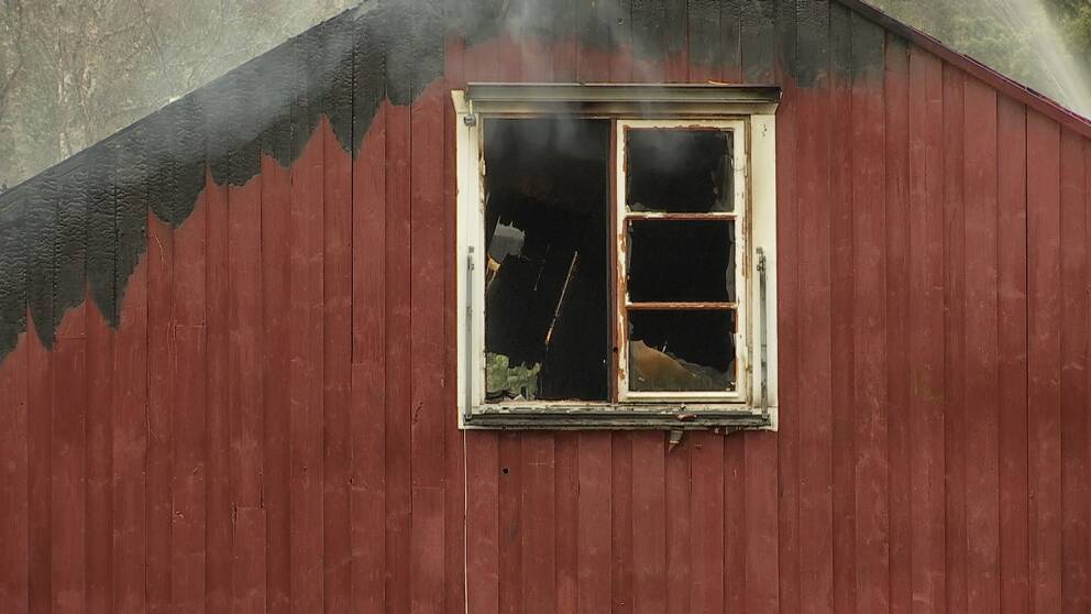 närbild på fönster i utbränt trähus