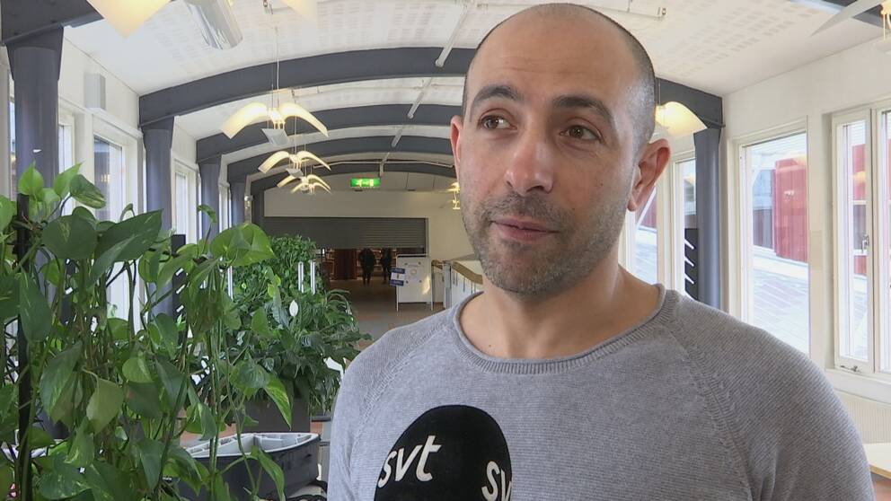 Hesham Ahmed i en korridor med en växt i bakgrunden.