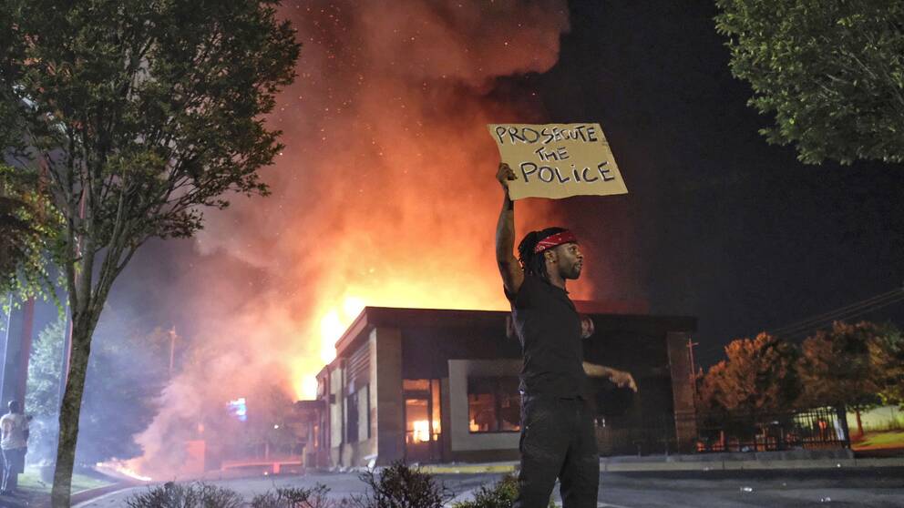Demonstranter har tänt eld på snabbmatsrestaurangen vid vilken en svart man sköts till döds av polis i Atlanta under fredagen
