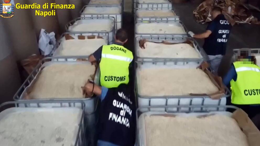 Bilder från polisen i Neapel när personal undersöker stora tråg med tabletter märkta med symbolen för captagon.