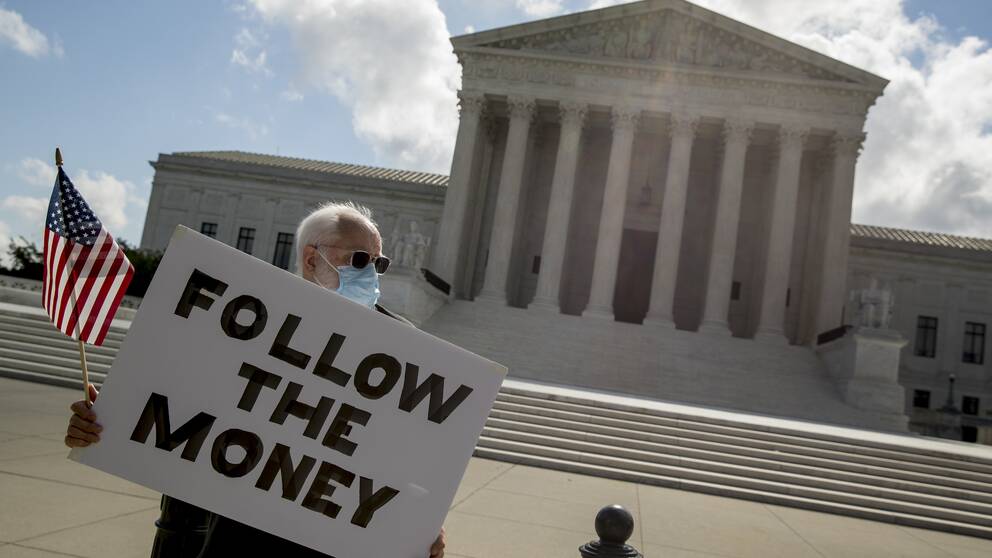 ”Följ pengarna.” En man vakade på torsdagen utanför HD i Washington DC.