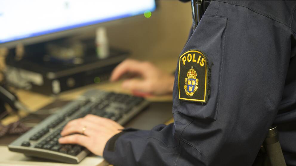 En polis arbetat vid en dator.