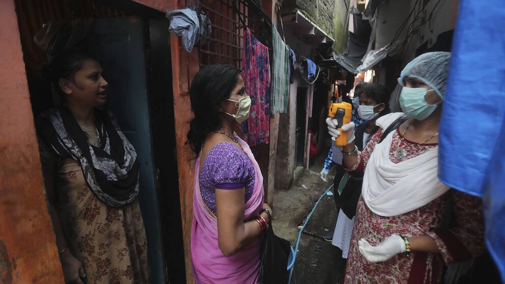 Sjukvårdspersonal screenar invånare i slumområdet Dharavi i Bombay, ett av de största slumområdena i Asien.