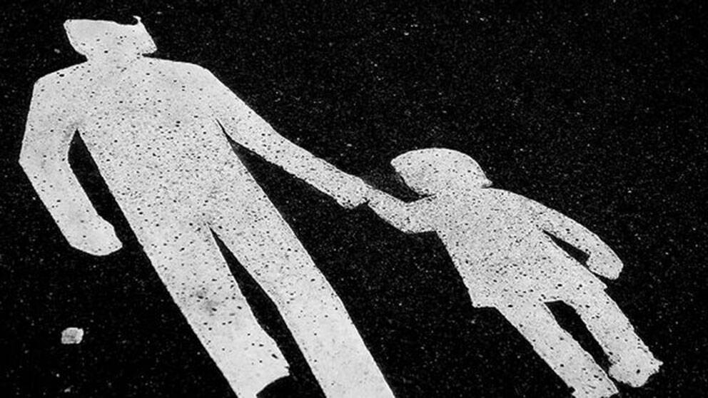genrebild på trafikmålning med vuxen som håller barn i hand
