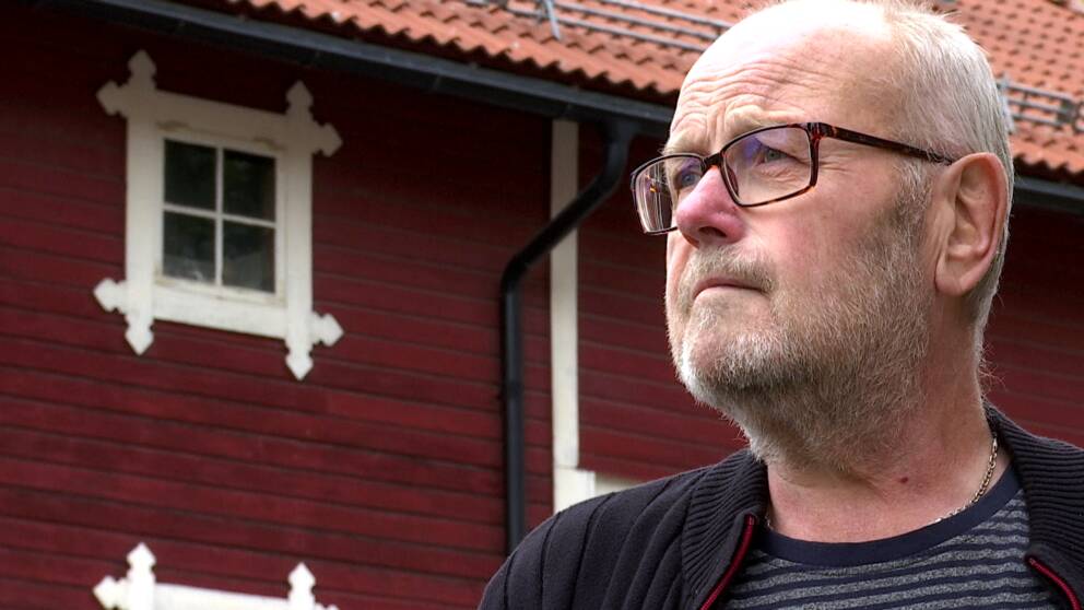 En man med glasögon blickar bortåt