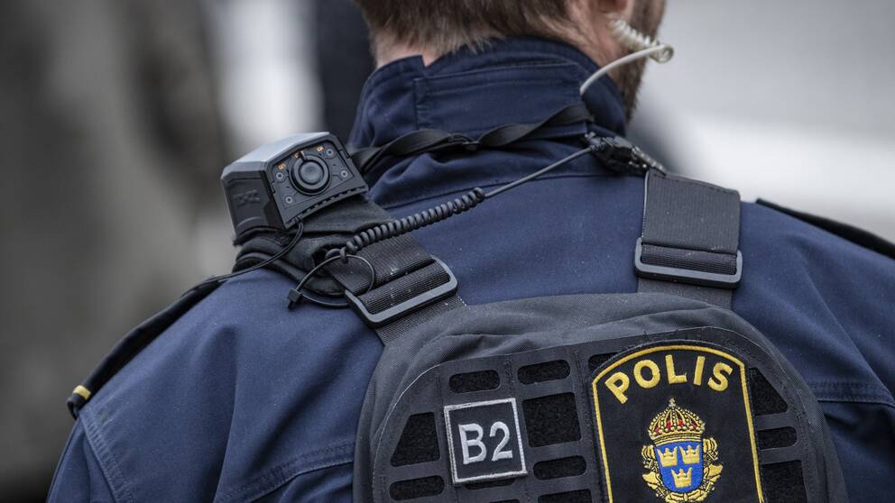 Bilden visar en polis bakifrån.