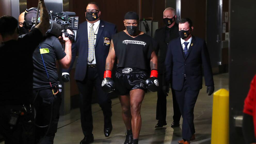Mike Tyson på väg mot ringen i sedvanlig helsvart utstyrsel.