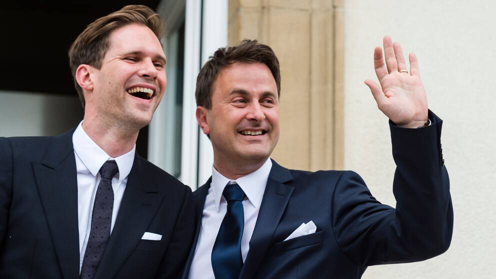 Luxemburgs premiärminister Xavier Bettel vinkar när han tillsammans med maken Gauthier Destenasy kommer ut deras vigsel.