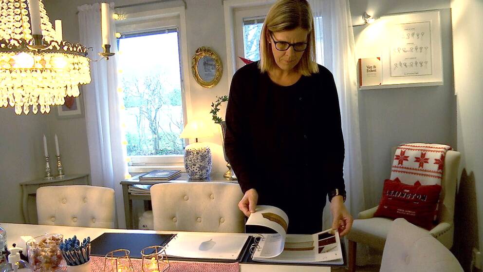 Begravningsentreprenör Annie Wårhem bläddrar i kistbroschyrer
