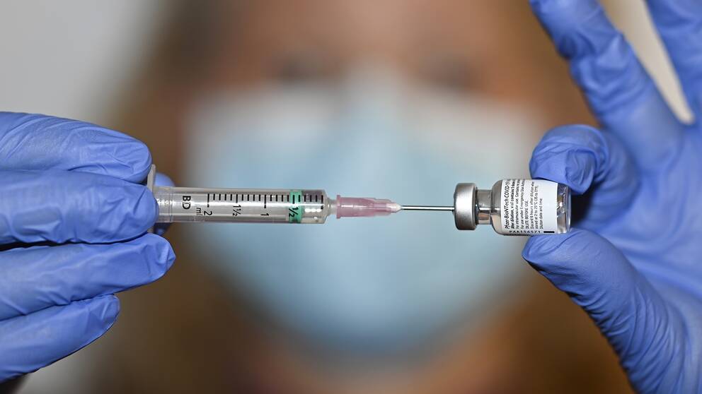 Kvinna med spruta med vaccin.