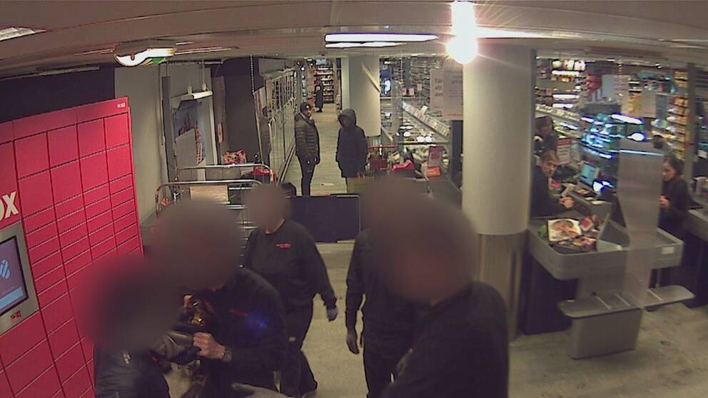 Övervakningsbild som visar butikspersonal som konfronterar en person som försökt stjäla en salami i mataffären. De står efter kassorna och en från butiken har tagit tag i kragen på tjuven. De inblandade personerna är anonymiserade.