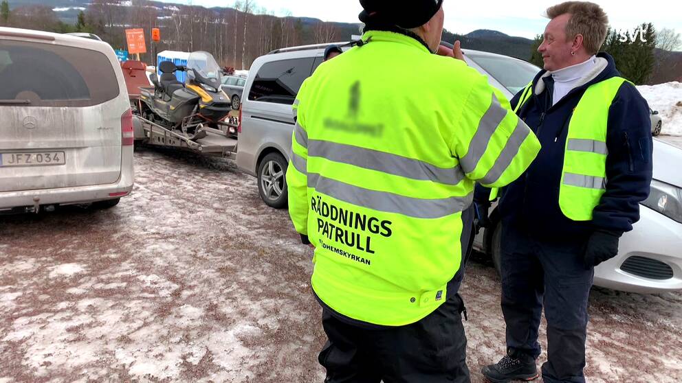 Två män från Vasaåkets räddningspatrull står på en parkering.