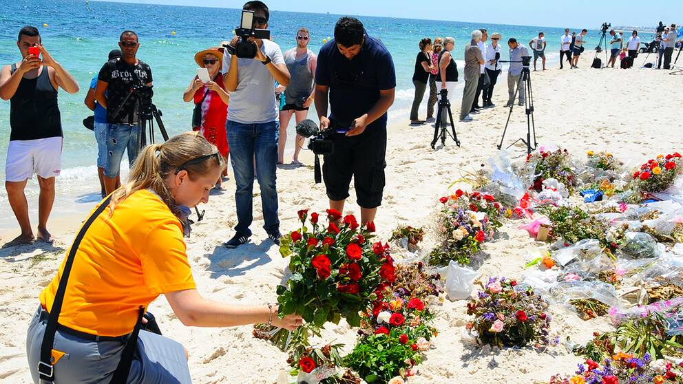 Tunisier och britter under en ceremoni på stranden i Sousse en vecka efter attacken.