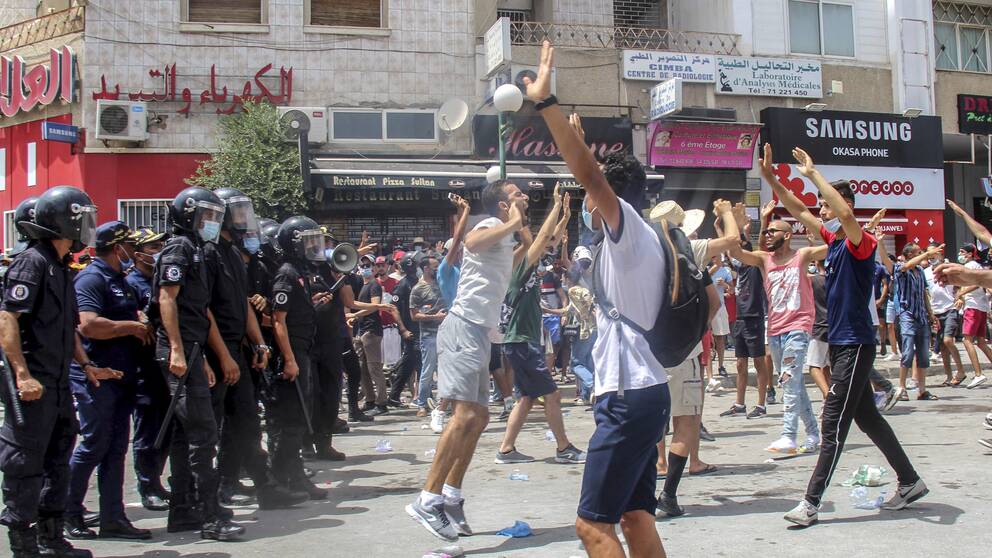 Demonstranter drabbar samman med polis i Tunisiens huvudstad Tunis under söndagen. Våldsamma demonstrationer har brutit ut på flera håll i landet i protest mot landets styre.