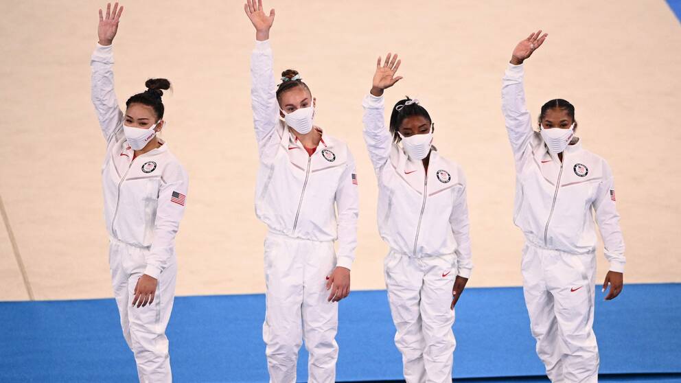 Simone Biles (näst längst till höger) hyllar sina lagkamrater, efter att hon själv tvingats bryta gårdagens lagfinal.