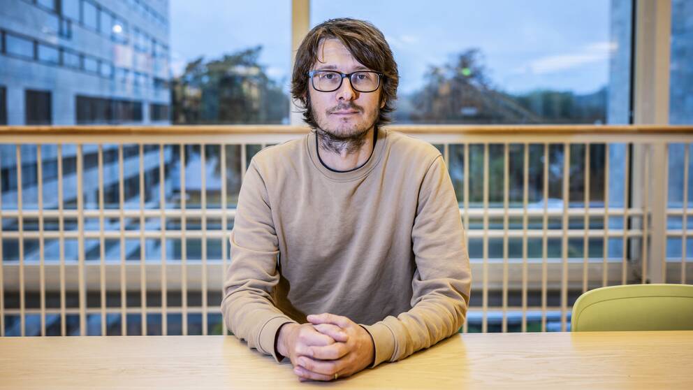 Manne Gerell sitter vid ett bord på Malmö Universitet.