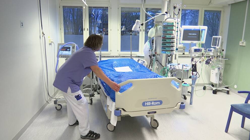 En sjukhussal där en personal flyttar en säng.