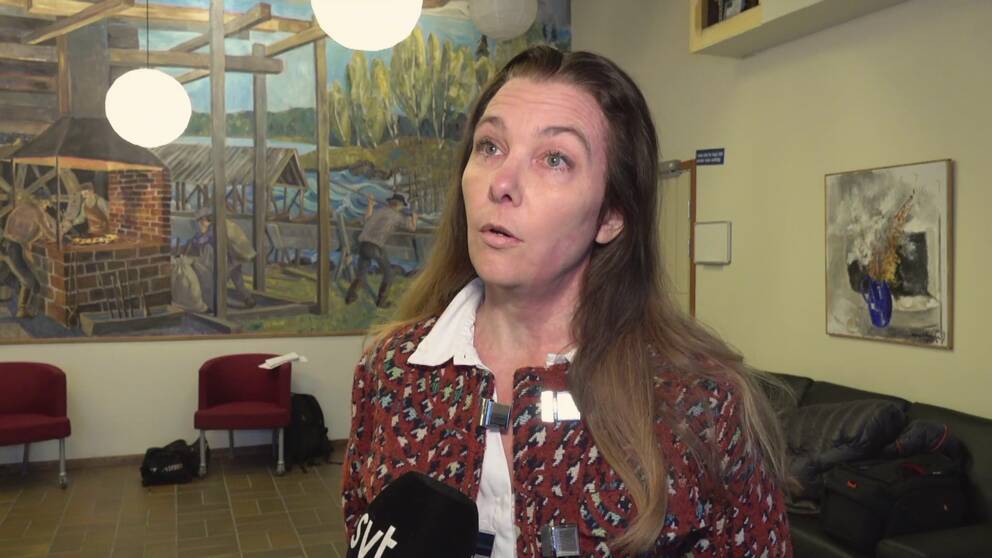 Carolina Ardesjö Lundén i röd kofta med svart och vitt hundtandsmönster.