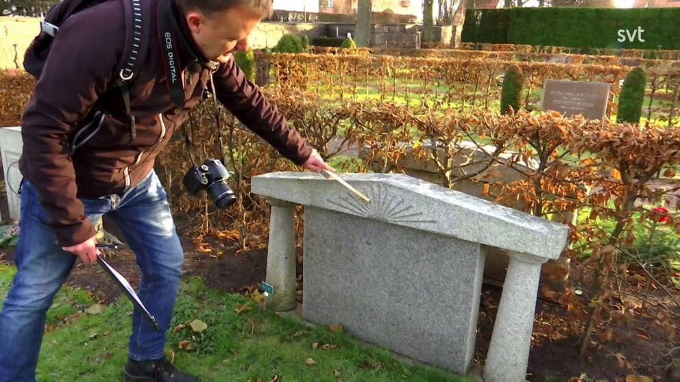 Jörgen Silverstig kontrollerar en gravsten, han är miljö- och kultursamordnare Linköpings domkyrkopastorat