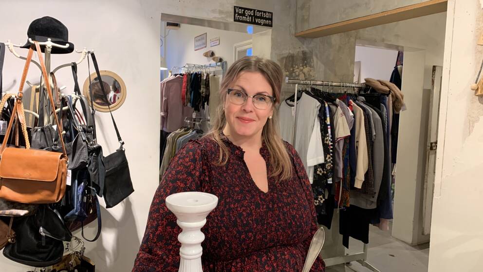 Kvinna med glasögon i hennes second hand-butik
