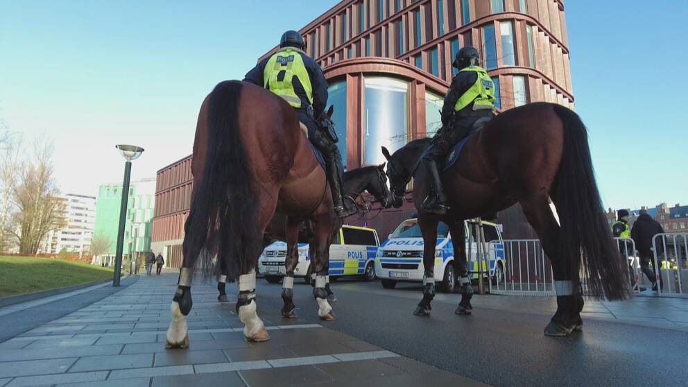 Två poliser på hästar i förgrunden och Lunds tingsrätt i bakgrunden.