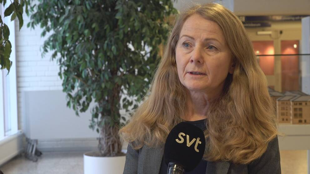 Kvinna framför en växt inomhus
