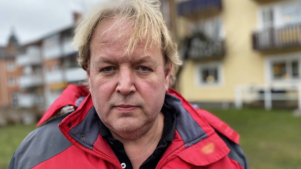 Jens Nyström i röd jacka står på en innergård i Strängnäs. 