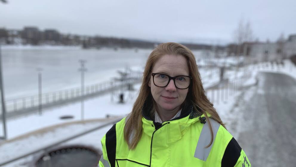 en kvinna med glasögon i varseljacka på strandpromenaden i Skellefteå, lite snö.