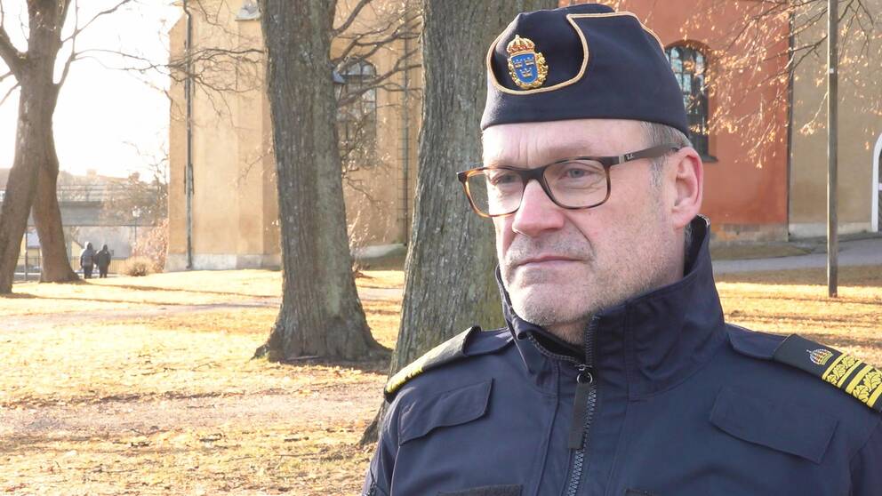 Bild på lokalpolisområdeschefen för Eskilstuna och Strängnäs, Christer Sjöqvist. Han har på sig uniform, hatt och glasögon. Han står utomhus i solljus. I bakgrunden skymtar Fors kyrka.
