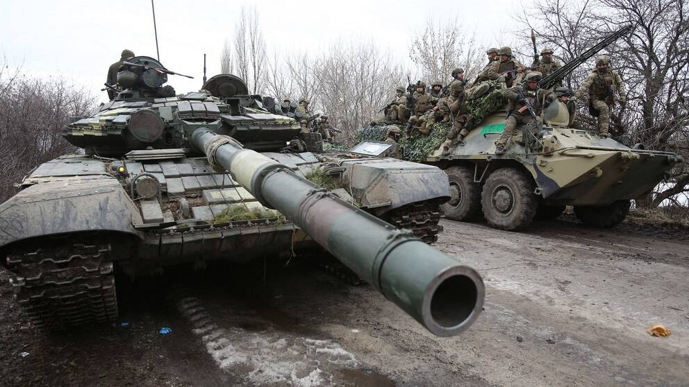 En stridsvagn och en bandvagn med soldater i Ukraina. Samma dag som ryssland anfallit Ukraina.
