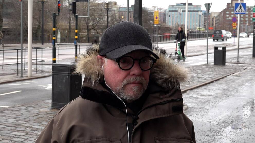 Bild på Johan som står utanför stadshuset i Stockholm.