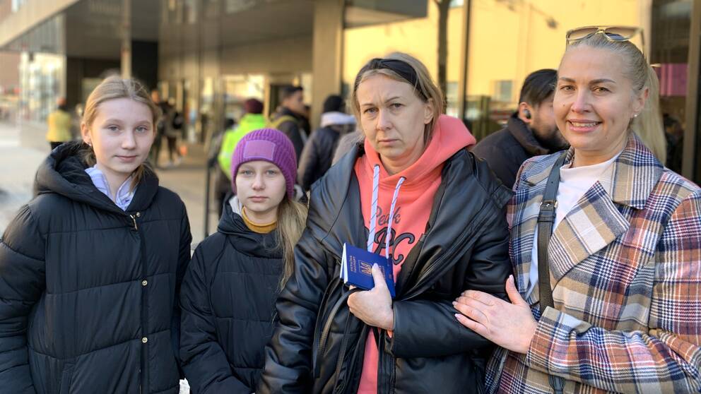 Två kvinnor och två barn utanför Migrationsverket.