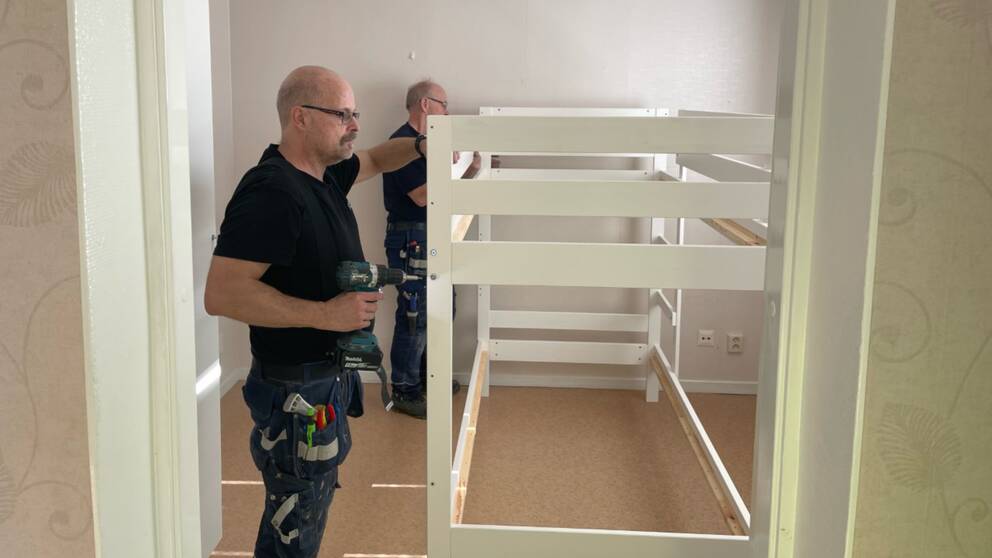 Två män snickrar på en våningssäng.