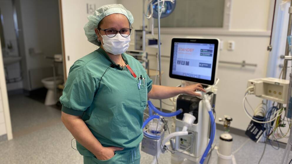 Läkare Annika Nilsson intill medicinsk utrustning i operationssal.