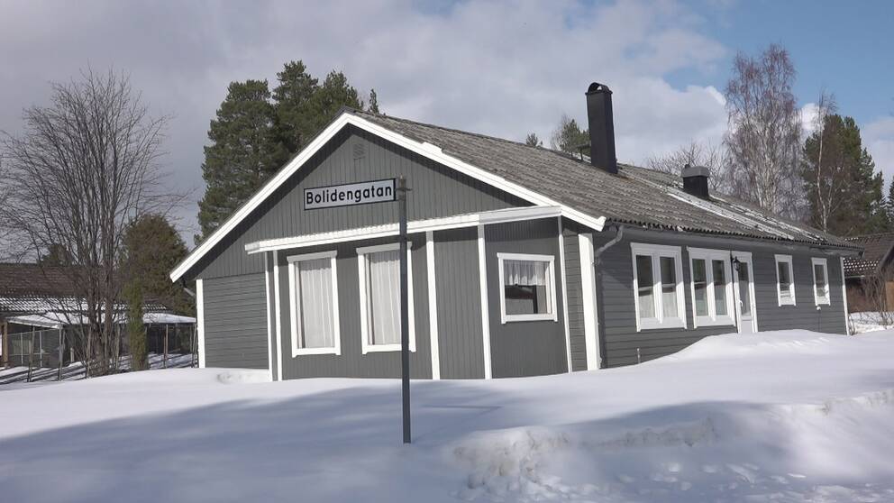 en grå enplansvilla i trä, snötäckt markt