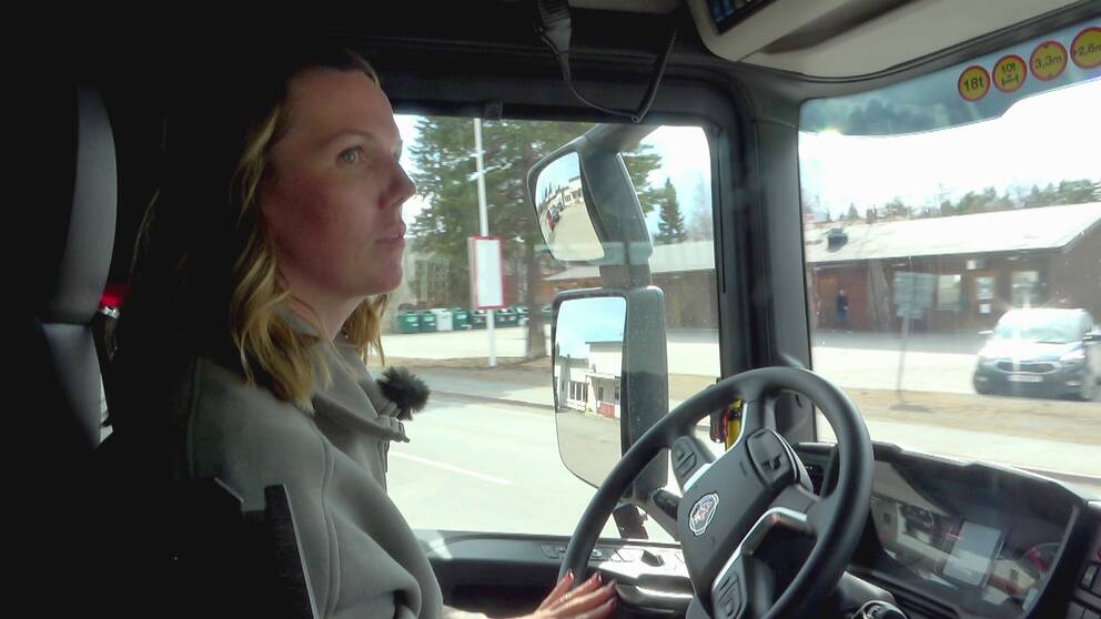 bild inne i hytten på brandbil, kvinna som kör