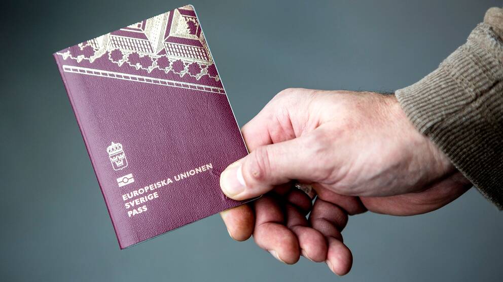 En man håller i ett svenskt pass.
