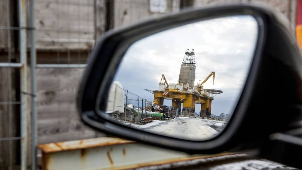 Oljerigg som syns i en bilspegel.
