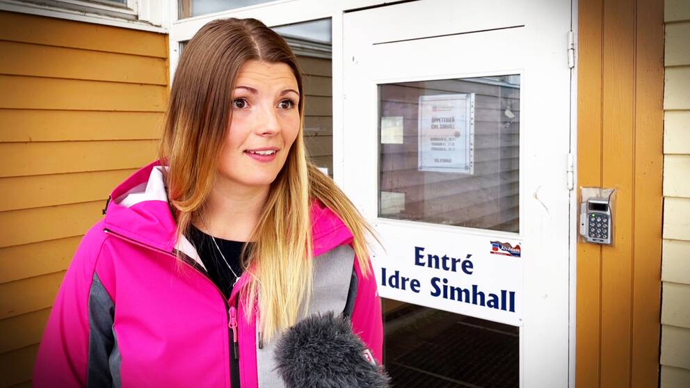 En kvinna står framför dörren till simhallen i Idre.