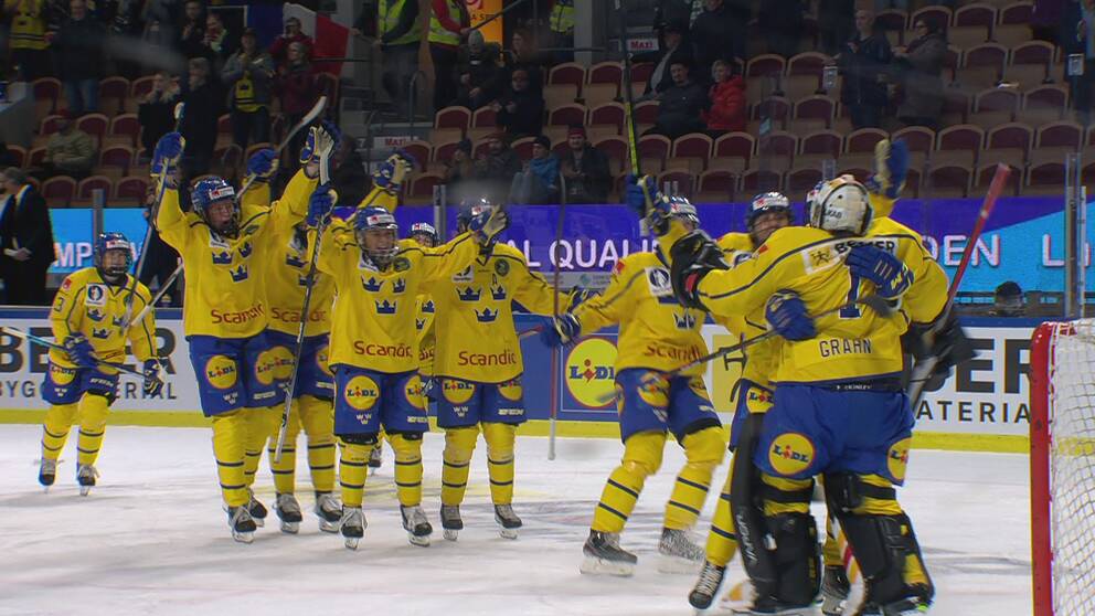 Ishockeyspelare i svensk landslagsdräkt jublar och kramar om målvakten.