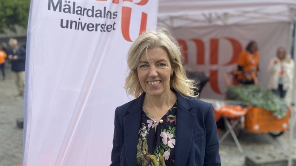 Helena Jerregård, vice rektor på Mälardalens universitet, framför universitetsflagga på stora torget i Västerås.