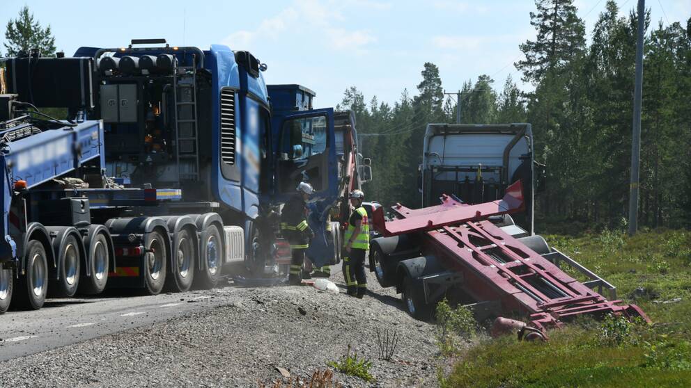 Bergningspersonal står mellan flera stora fordon. En lastbil med släp står i diket utanför vägen.